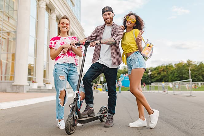 un homme et deux femmes avec une trottinette electrique adulte