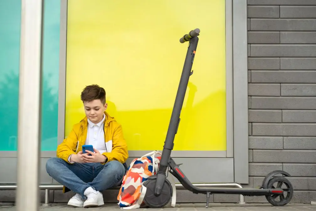 jeune garçon et sa trottinette électrique