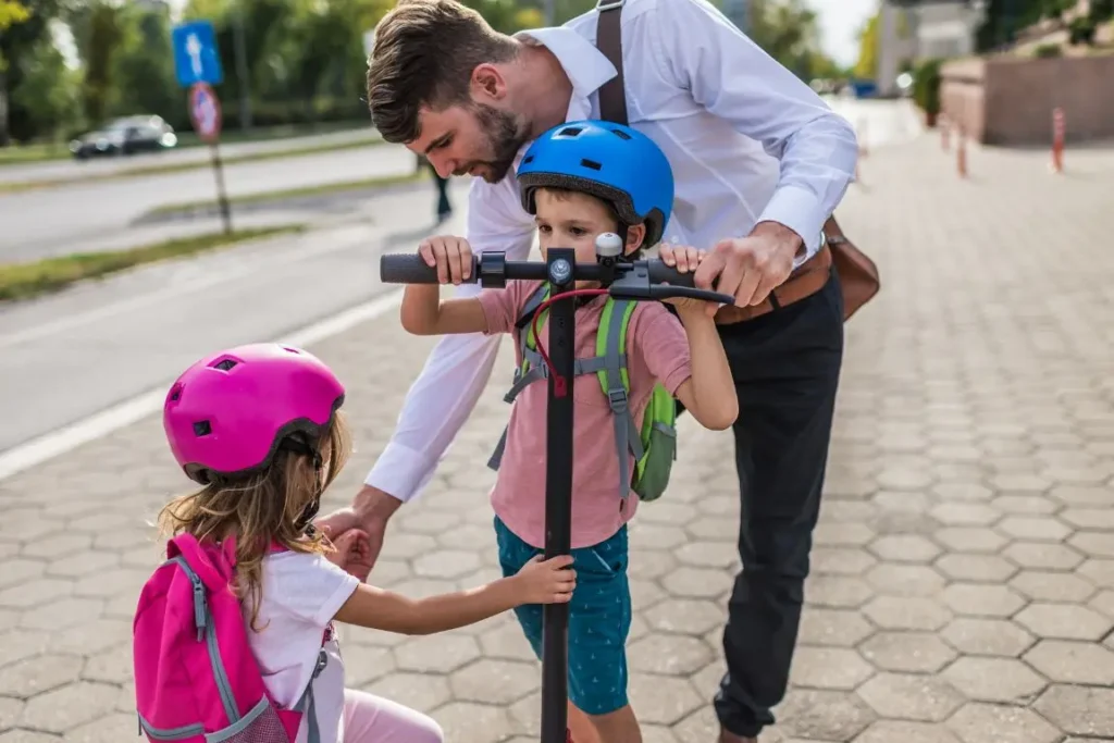 papa avec ces enfants et une trottinette électrique